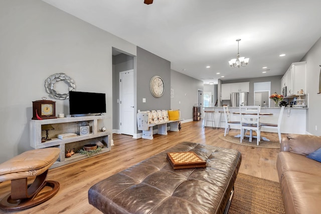 living room with a chandelier and light wood-type flooring