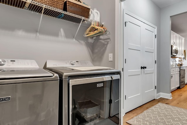 washroom featuring independent washer and dryer and light hardwood / wood-style flooring