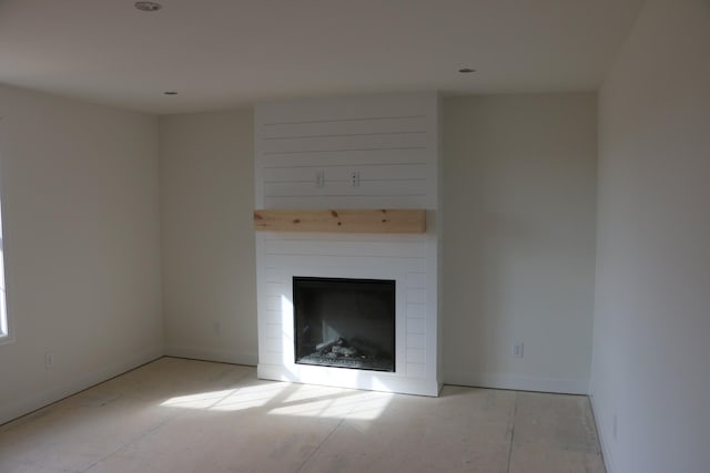 unfurnished living room featuring a large fireplace