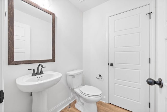 bathroom with hardwood / wood-style floors and toilet