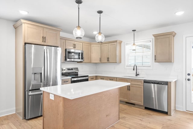 kitchen with hanging light fixtures, sink, a center island, and stainless steel appliances