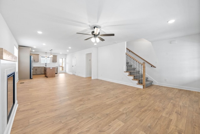 unfurnished living room with ceiling fan and light hardwood / wood-style floors