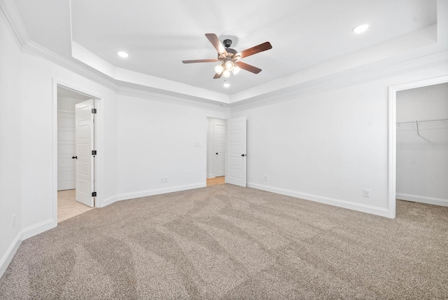 unfurnished bedroom with a tray ceiling and light carpet