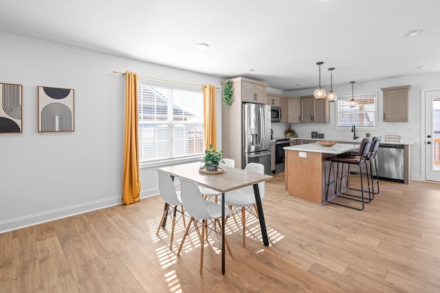 dining area with light wood-type flooring and baseboards