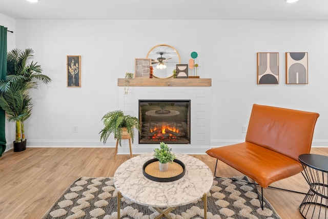 sitting room featuring recessed lighting, baseboards, wood finished floors, and a glass covered fireplace