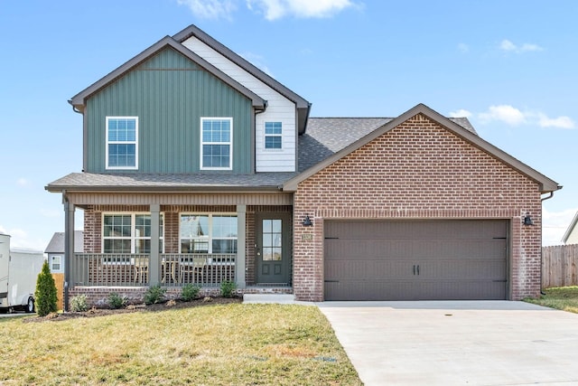 view of front of house featuring a porch, an attached garage, brick siding, driveway, and a front yard