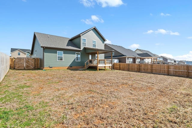 back of property with crawl space, a residential view, a fenced backyard, and a lawn