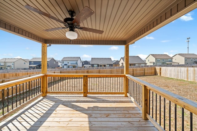 wooden deck featuring ceiling fan, a fenced backyard, and a residential view