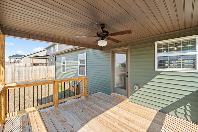 wooden terrace with ceiling fan and fence