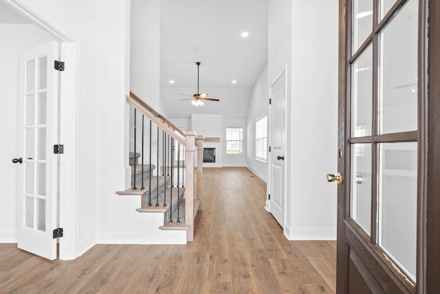 entrance foyer with ceiling fan, light wood-type flooring, and vaulted ceiling