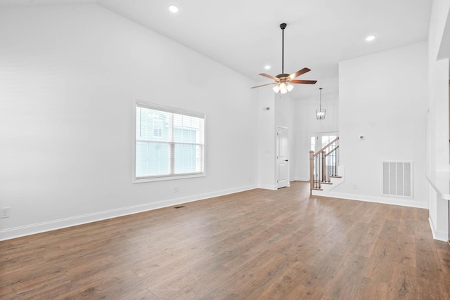 unfurnished living room with hardwood / wood-style flooring, high vaulted ceiling, and ceiling fan