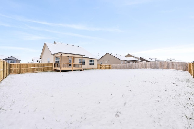 snowy yard featuring a wooden deck