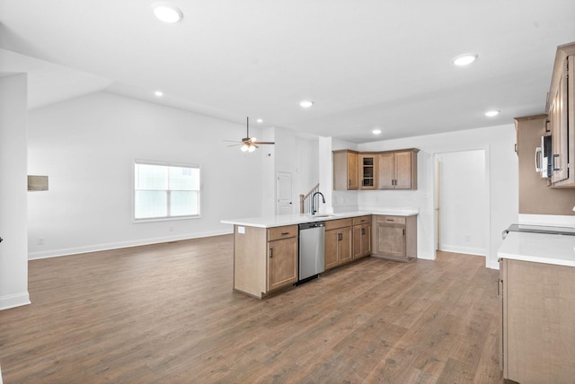 kitchen with sink, vaulted ceiling, hardwood / wood-style flooring, appliances with stainless steel finishes, and kitchen peninsula