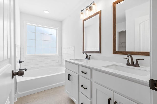 bathroom featuring tile patterned floors, vanity, and a tub to relax in