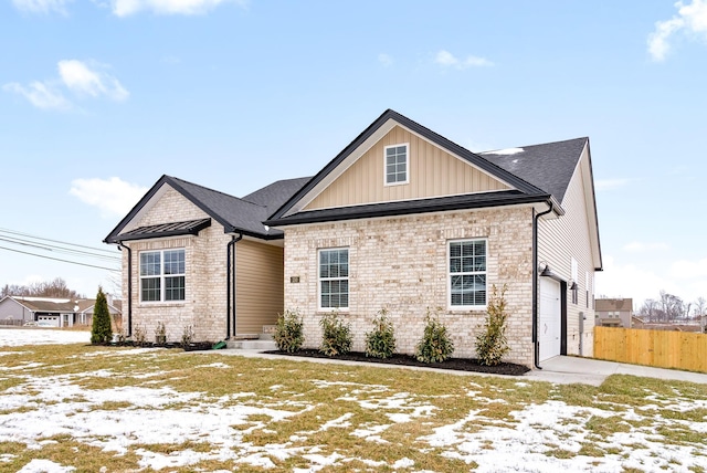 view of front of property featuring board and batten siding, brick siding, fence, and a shingled roof