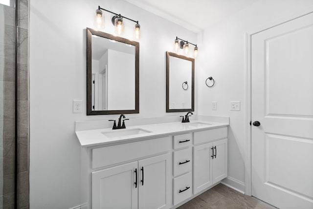 full bath featuring a sink, baseboards, and double vanity