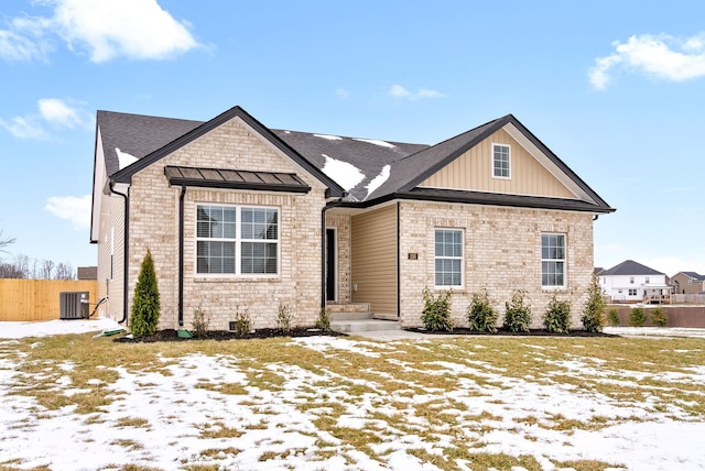 view of front of home featuring brick siding, board and batten siding, fence, and central air condition unit