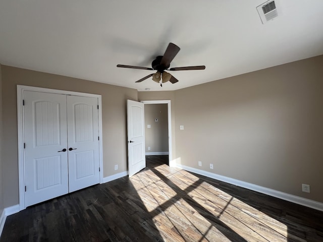 unfurnished bedroom featuring a closet, ceiling fan, and dark wood-type flooring