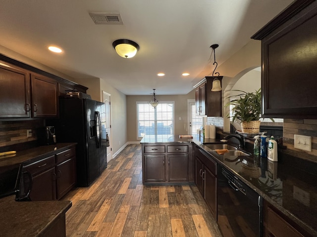 kitchen with sink, dark hardwood / wood-style flooring, kitchen peninsula, pendant lighting, and black appliances