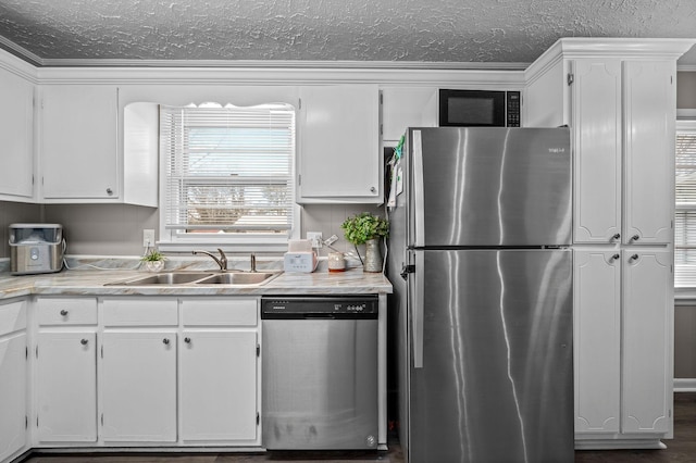 kitchen with white cabinets, sink, dark hardwood / wood-style floors, ornamental molding, and appliances with stainless steel finishes