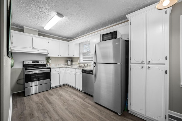 kitchen featuring sink, white cabinets, stainless steel appliances, and ornamental molding