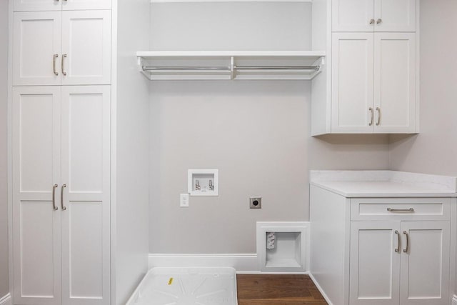 laundry area featuring electric dryer hookup, dark wood-type flooring, hookup for a washing machine, and cabinets