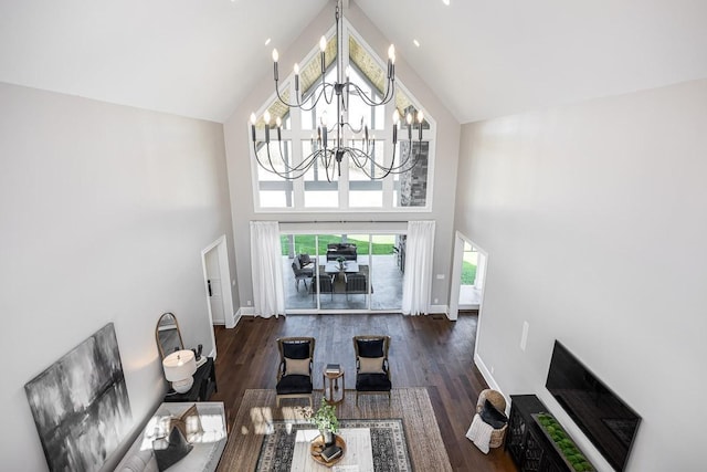 living room featuring dark hardwood / wood-style flooring, high vaulted ceiling, and a notable chandelier