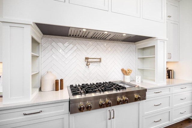 kitchen with decorative backsplash, light stone countertops, dark hardwood / wood-style flooring, white cabinets, and stainless steel gas stovetop