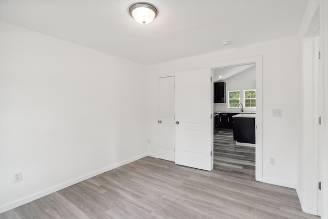 empty room featuring hardwood / wood-style flooring and lofted ceiling