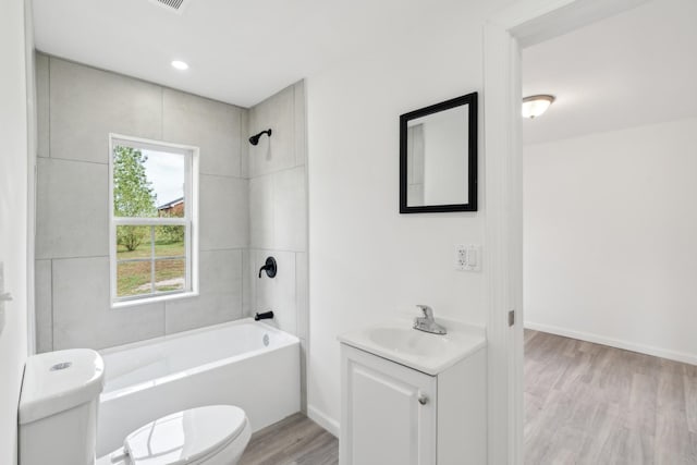 full bathroom featuring toilet, vanity, tiled shower / bath combo, and hardwood / wood-style flooring