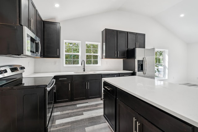 kitchen with light hardwood / wood-style floors, sink, lofted ceiling, and stainless steel appliances