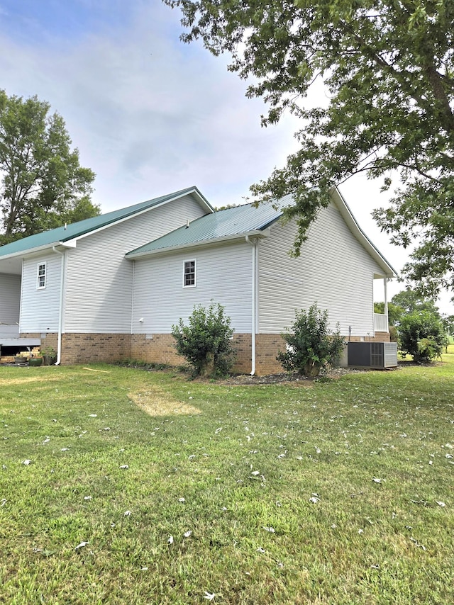 view of property exterior with central AC and a yard