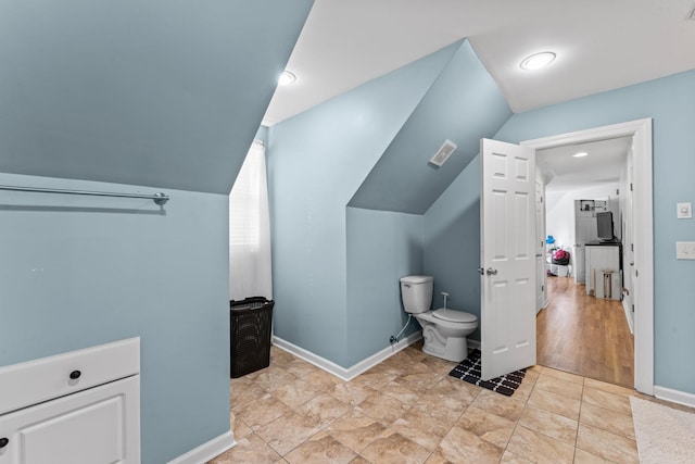 bathroom featuring toilet, tile patterned flooring, and vaulted ceiling