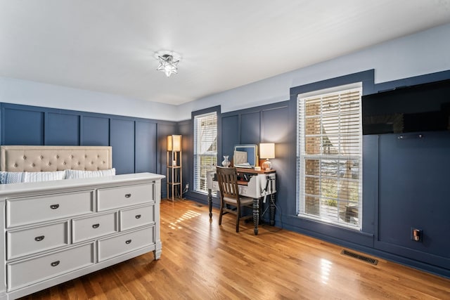 bedroom with multiple windows and light hardwood / wood-style floors