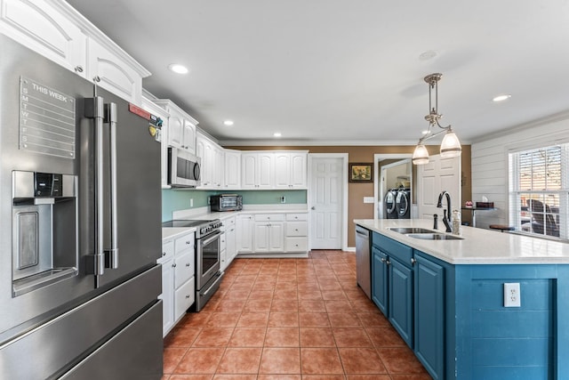 kitchen featuring stainless steel appliances, a kitchen island with sink, blue cabinetry, white cabinets, and sink