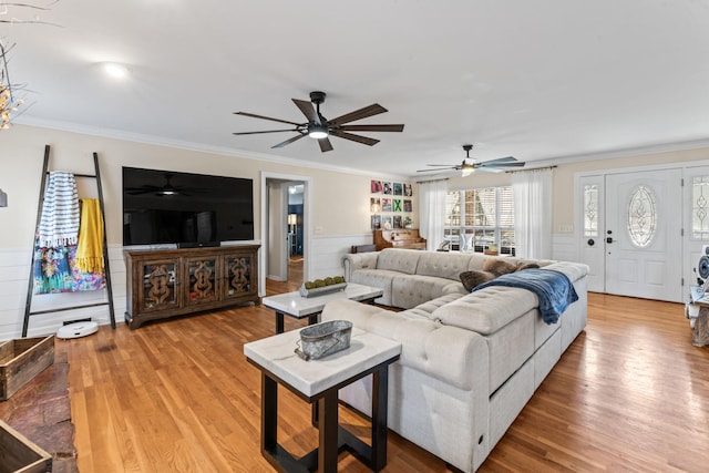 living room with ceiling fan, light hardwood / wood-style flooring, built in features, and crown molding