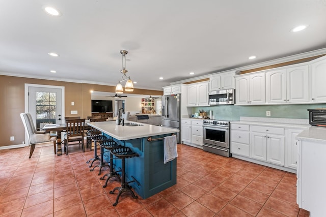 kitchen featuring sink, white cabinetry, hanging light fixtures, and appliances with stainless steel finishes