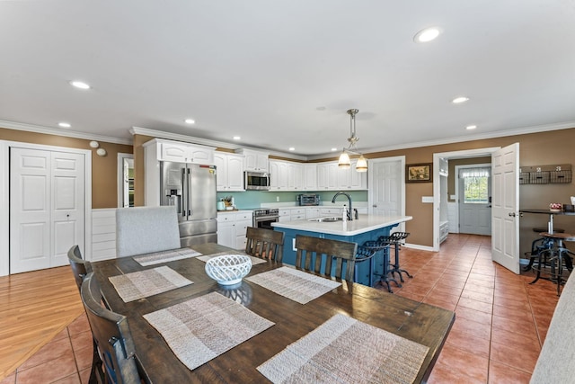 dining space featuring sink, tile patterned flooring, and crown molding