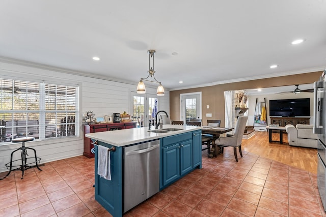 kitchen featuring sink, an island with sink, stainless steel dishwasher, tile patterned floors, and blue cabinetry