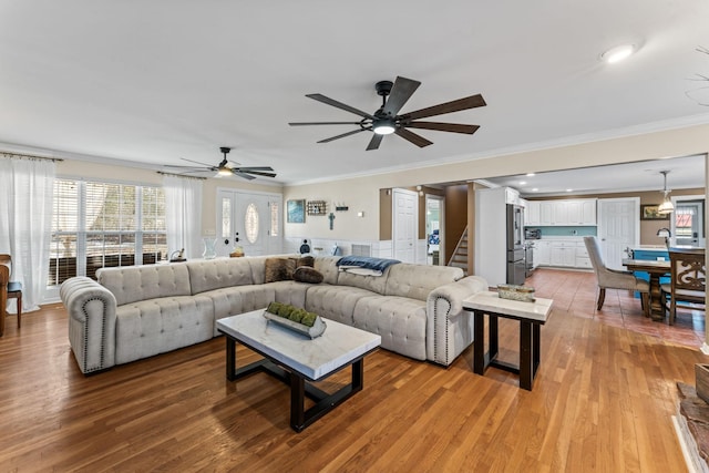 living room featuring ornamental molding, ceiling fan, and light hardwood / wood-style flooring