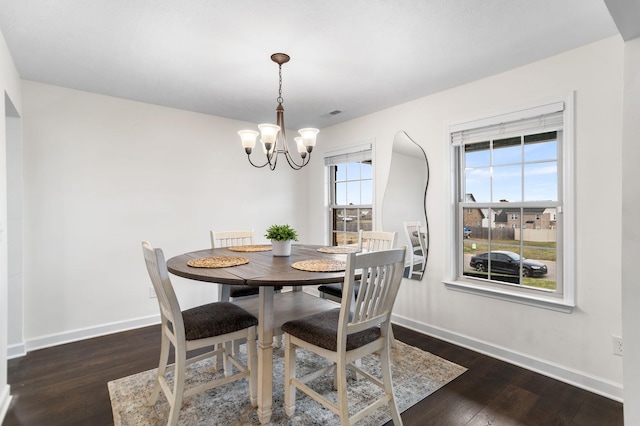 dining room with dark hardwood / wood-style floors and a notable chandelier