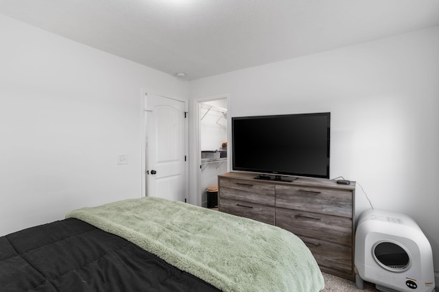 bedroom featuring carpet flooring, a walk in closet, and a closet