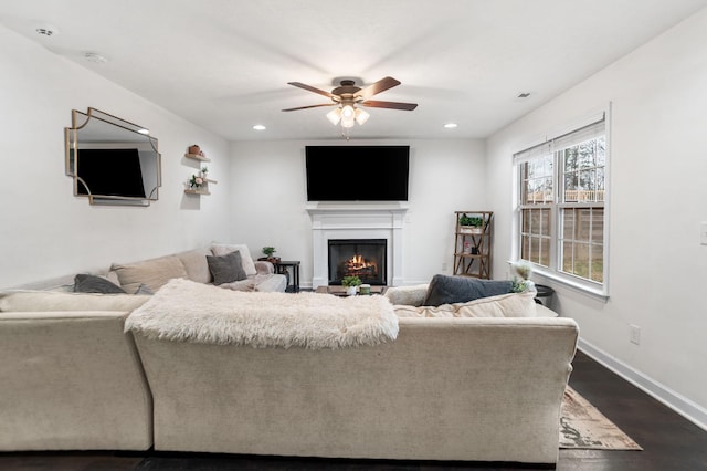 living room featuring ceiling fan and dark hardwood / wood-style floors