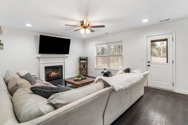 living room with ceiling fan and dark hardwood / wood-style flooring