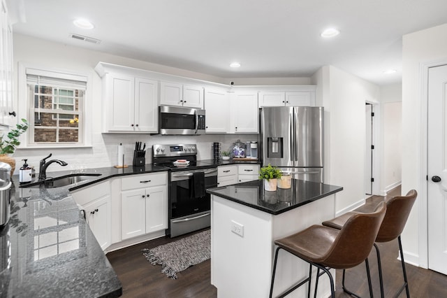 kitchen with white cabinets, appliances with stainless steel finishes, and a center island