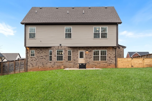 rear view of property featuring a patio and a lawn