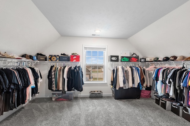 walk in closet featuring carpet floors and lofted ceiling