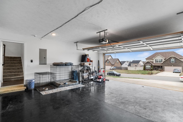 garage with electric panel and a garage door opener