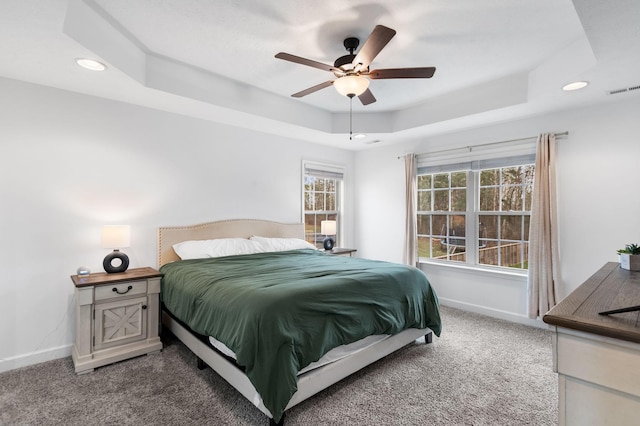 bedroom with carpet, ceiling fan, and a raised ceiling