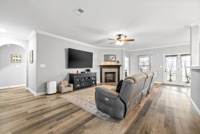 living room with ornamental molding, ceiling fan, a fireplace, and wood-type flooring